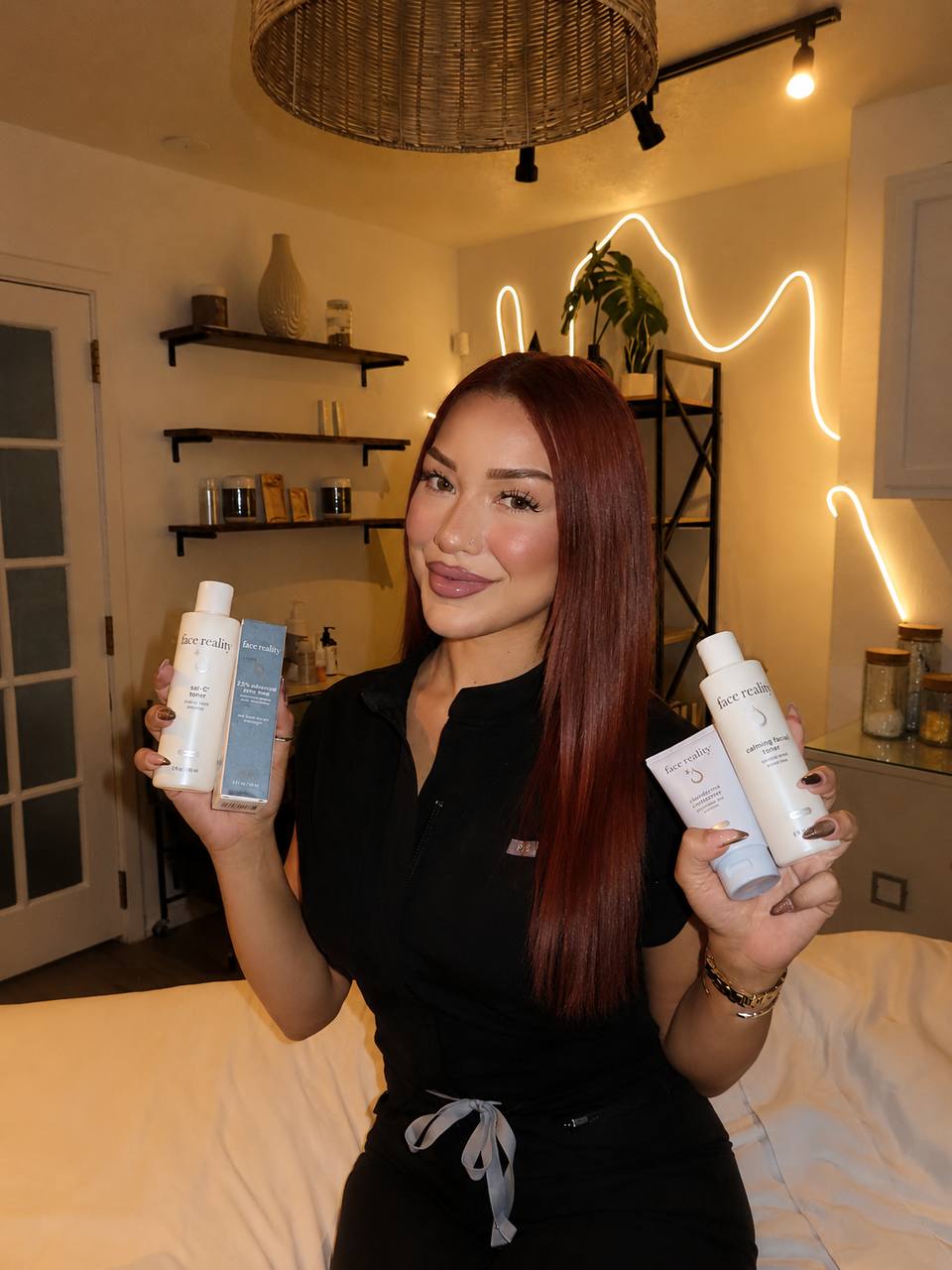 Onyx, licensed esthetician at Onyx Skin Co., holding professional skincare products